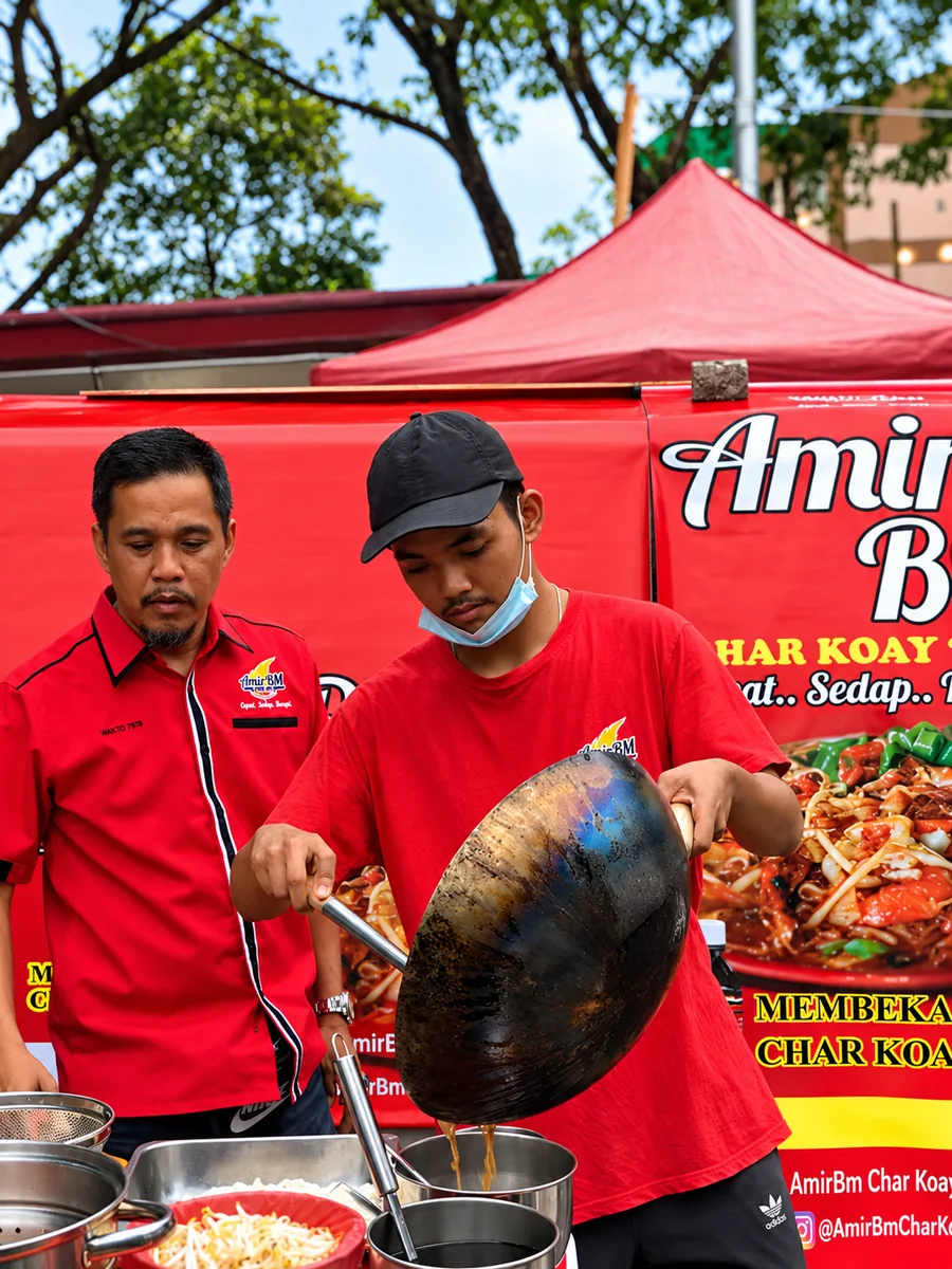 Usahawan AmirBM menggoreng Char Koay Teow bersama jurulatih
